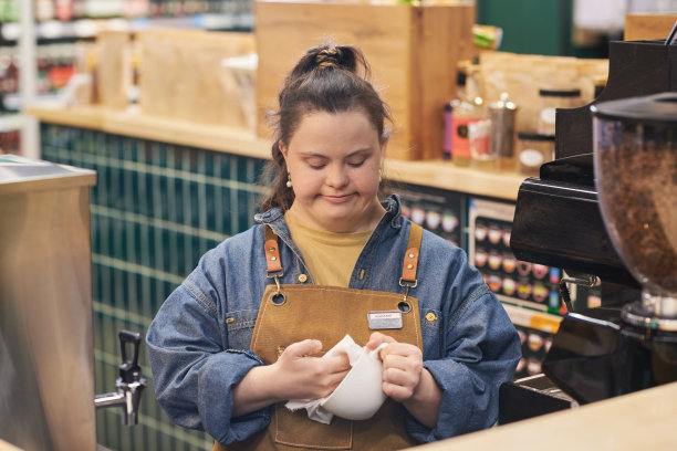 患有唐氏综合症的女孩在咖啡馆工作图片下载