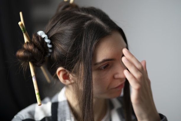 时尚的年轻女孩与艺术发型和筷子在亚洲风格摆姿势随意的肖像图片下载