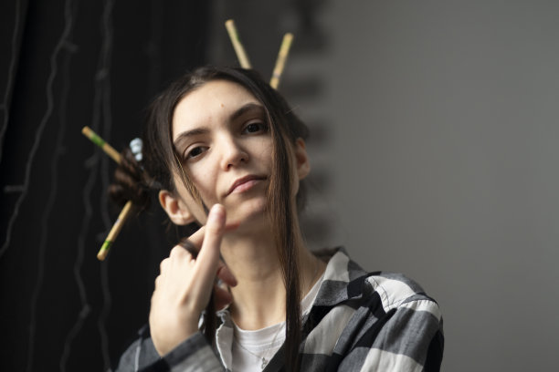时尚的年轻女孩与艺术发型和筷子在亚洲风格摆姿势随意的肖像图片下载