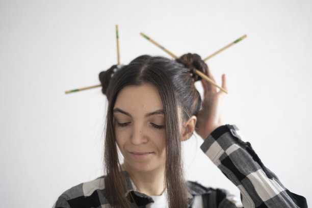 时尚的年轻女孩与艺术发型和筷子在亚洲风格摆姿势随意的肖像图片下载