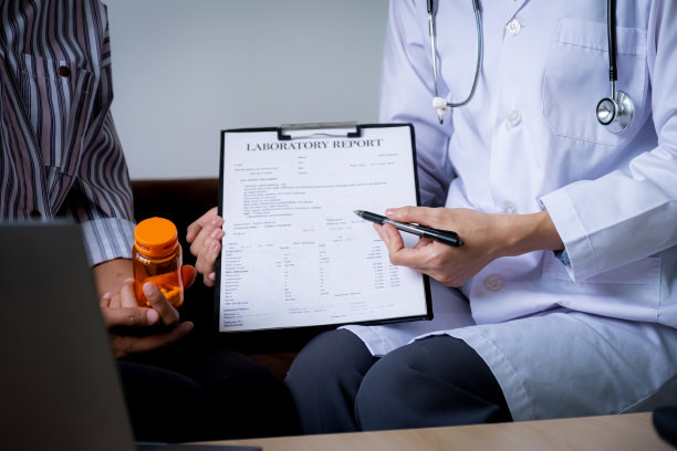 医生在家里的沙发上向病人解释药瓶，并报告健康检查结果，医疗检查的概念图片下载