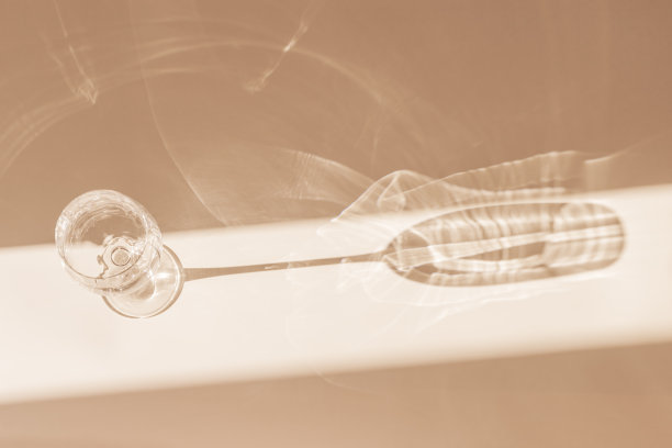 阳光洒在酒杯上为酒，顶景酒杯在阳光下闪闪发光，静物与闪亮的酒杯，米色背景与阴影和阳光的眩光，极简趋势美学创意照片，空白空间图片下载