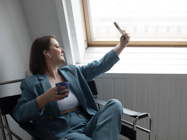 一个胖乎乎的女人坐在窗边的椅子上自拍图片下载