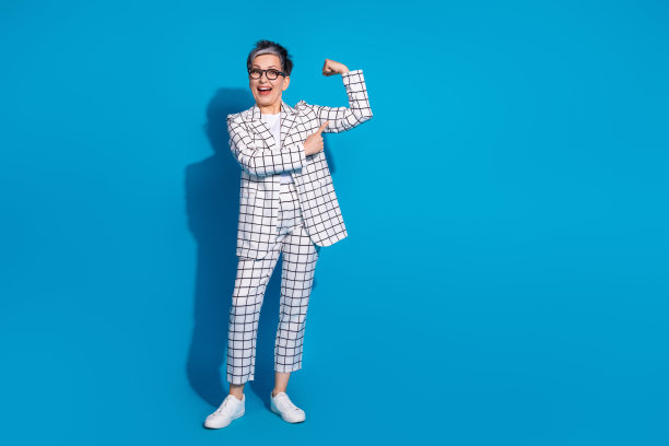 照片中美丽开朗的女人穿着白色时尚的衣服，肌肉空白的空间孤立在蓝色的背景上图片下载