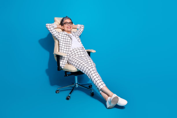 照片的华丽可爱的高兴的女人穿着白色时髦的衣服享受度假舒适的椅子孤立的蓝色背景图片下载