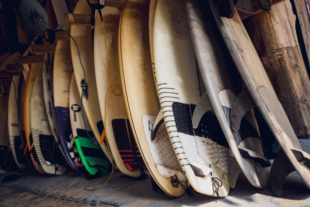 各种各样的冲浪板整齐地陈列在一个架子上图片下载