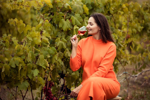 年轻女子端着一杯以葡萄为背景的饮料图片下载