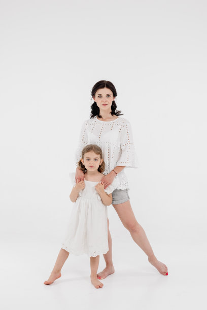 一位穿着浅色衣服的母亲正在和一个可爱的小女孩玩得很开心。母亲和小女儿被隔离在白色背景上。母亲节，爱，家庭，亲子，童年的概念。图片下载