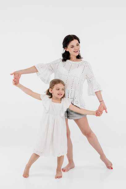 一位穿着浅色衣服的母亲正在和一个可爱的小女孩玩得很开心。母亲和小女儿被隔离在白色背景上。母亲节，爱，家庭，亲子，童年的概念。图片下载