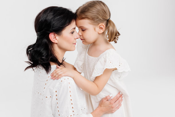 母女之间的家庭关系。感性的母亲和她的小女儿在灯光工作室背景。温情时刻，家人支持。图片下载