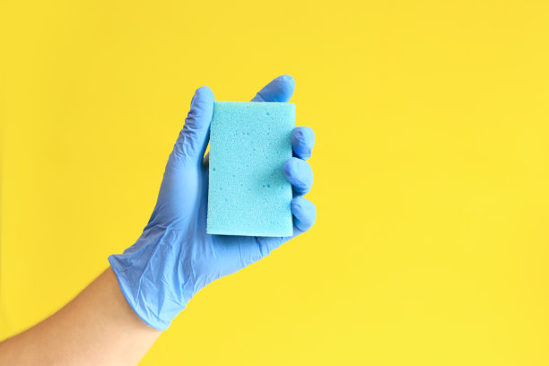 男人的手戴着带海绵的乳胶手套图片下载