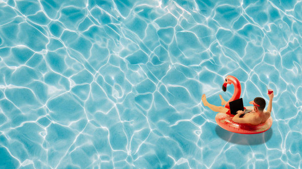 当代艺术拼贴。男子在游泳火烈鸟圈漂浮在游泳池和网上工作，喝鸡尾酒。抽象的艺术作品。图片下载