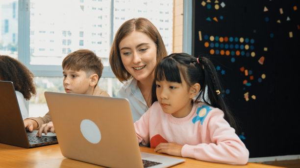 非洲女孩玩笔记本电脑与多元文化的朋友学习提示。博学。图片下载