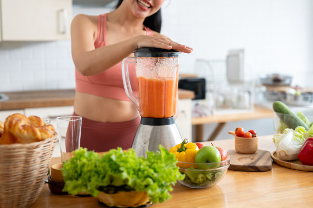 一个穿着运动服的女人在厨房用搅拌器做奶昔的图片。图片下载