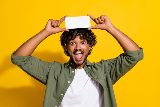 年轻的阿拉伯学生男生的照片广告现代移动应用程序持有智能手机显示孤立的黄色背景图片下载