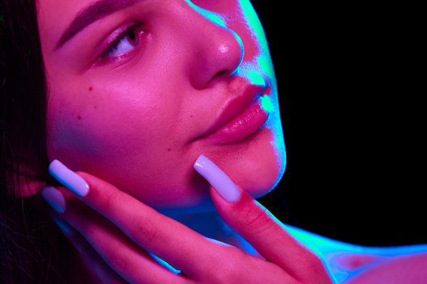 深层面部清洁。在霓虹灯的黑色工作室背景下，迷人的年轻女孩素颜的照片展示了她完美透明的皮肤图片下载
