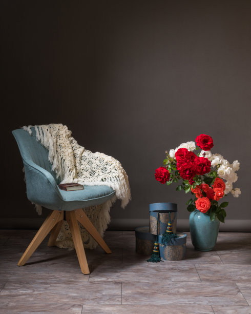 坑的设计。图片区。一张舒适的蓝色椅子上有一条白色的围巾。花盆上放着一个大花瓶，上面放着一大束鲜花。礼品盒就堆放在附近。图片下载