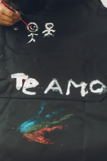 父亲节那天，一个男孩用水彩画了一件t恤，上面写着西班牙语。图片下载