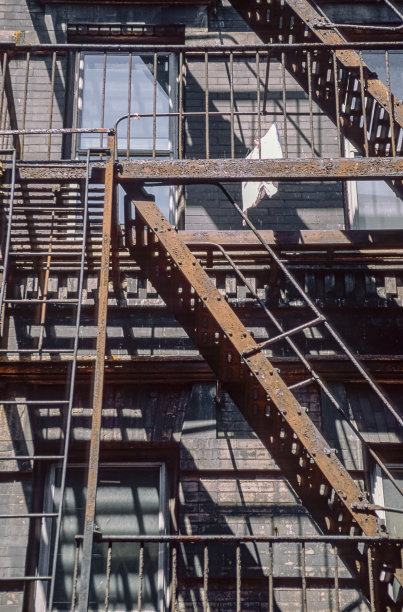 一张历史彩色照片的扫描幻灯片，显示一栋住宅楼的正面，防火梯锈迹斑斑，栏杆破旧图片下载