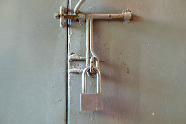 安全不锈钢挂锁的大门上的小灰色集装箱关闭。高质量照片图片下载