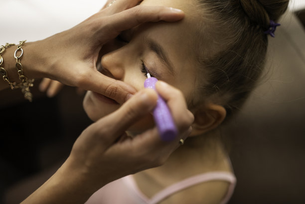 一个小学生的肖像。她正在后台为芭蕾舞表演化妆。股票的照片。图片下载