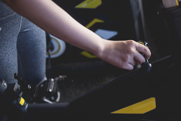 一位不愿透露姓名的女士正在调整固定自行车的把手高度。图片下载