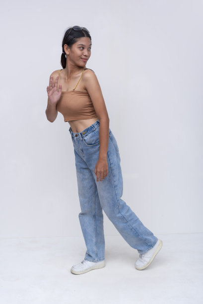 一位年轻的菲律宾女子走在路上，愉快地回头看了看。全身照片，孤立在白色背景上。图片下载