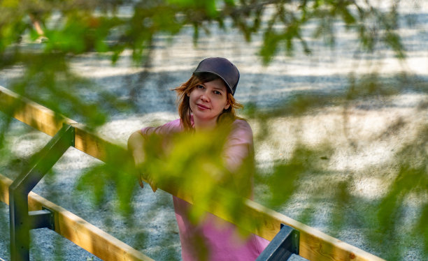 年轻女子在大自然:迷人的肖像透过树叶图片下载