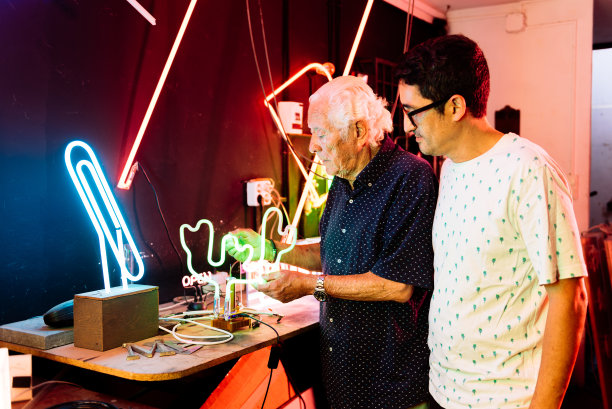 父子俩在工作室里制作霓虹灯图片下载