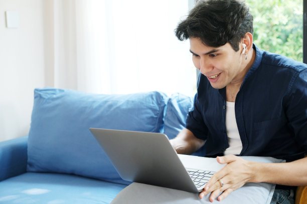 年轻人一边惊讶地看着笔记本电脑，一边在家工作图片下载