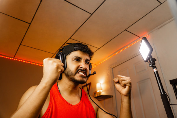 成年男子戴着游戏头盔庆祝的肖像。图片下载