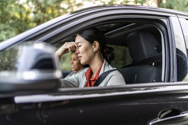 年轻的女商人在开车时头痛。图片下载