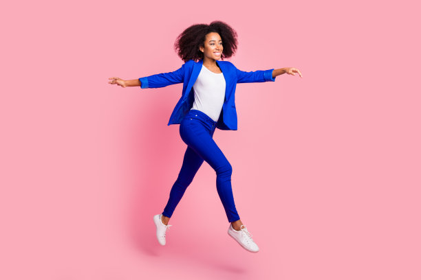 照片中开朗迷人的漂亮女孩穿着时髦的蓝色衣服，在粉红色的背景上显得空无一物图片下载