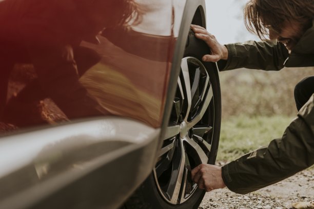 男子检查汽车轮胎照片图片下载