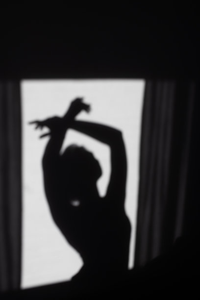 黑暗中一个女人的剪影。影子图片下载