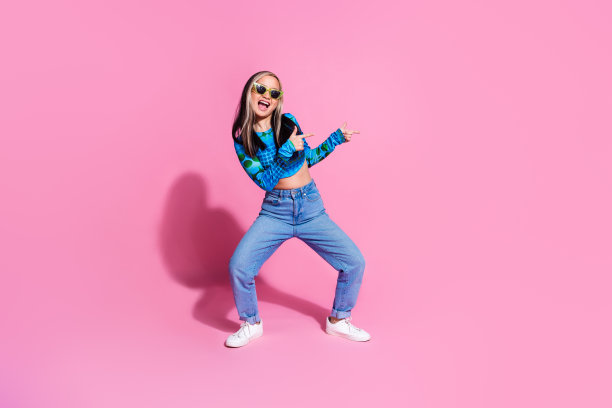 照片中闪亮女士穿着印花衬衫，深色眼镜微笑，空白空间孤立的粉红色背景图片下载