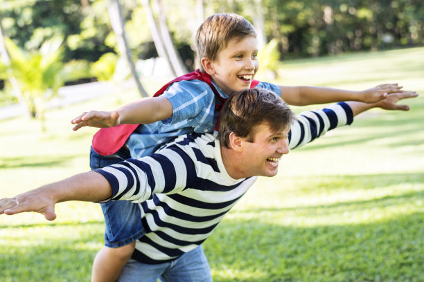 超级英雄男孩骑在他爸爸的背上飞翔图片下载