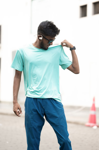 一个微笑的男人走在人行道上看向别处图片下载