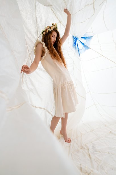 穿着白色礼服的女人在白色的织物结构中摆姿势图片下载