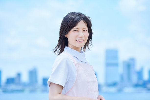 一位身穿白大褂、系着围裙的年轻女子图片下载