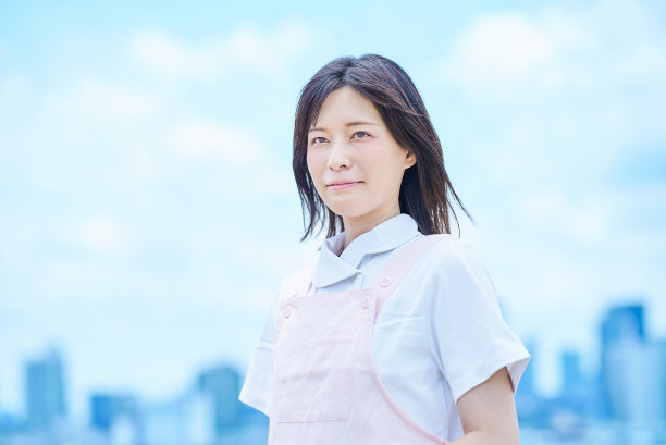 一位身穿白大褂、系着围裙的年轻女子图片下载