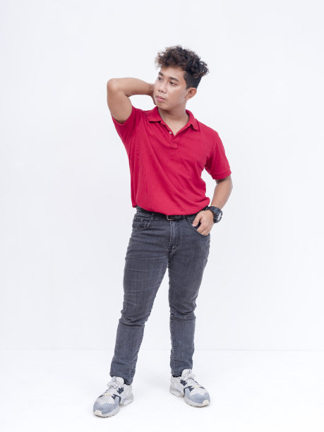 一个自信的菲律宾男人，一头卷发，穿着红色polo衫和蓝色牛仔裤。全身照片，孤立在白色背景上。图片下载