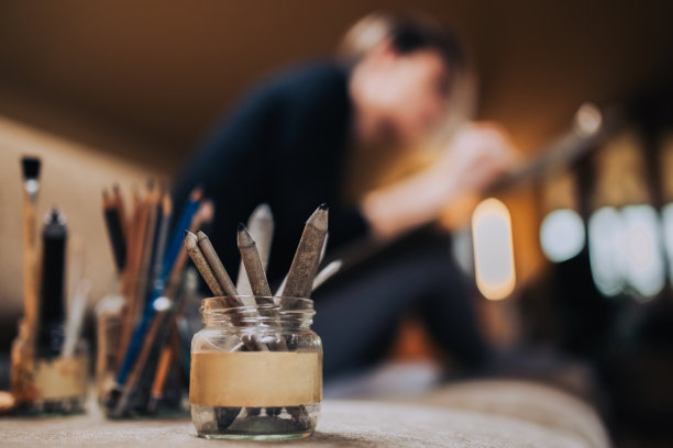 沙发上铅笔罐里的特写，背景模糊的艺术家。图片下载