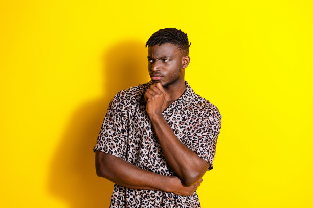 照片中，严重沮丧的悲伤男子穿着时髦的衣服，在鲜艳的黄色背景上显得空虚孤立图片下载