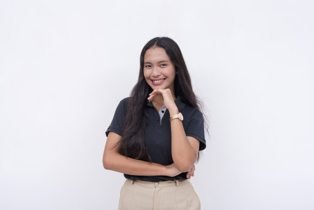 一位年轻迷人的女企业家手放在下巴上看着镜头。一个穿着漂亮休闲装的可靠而能干的雇员。孤立在白色背景上。图片下载