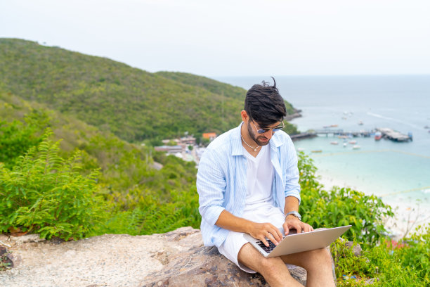 暑假在热带岛屿上用笔记本电脑工作的商人。图片下载