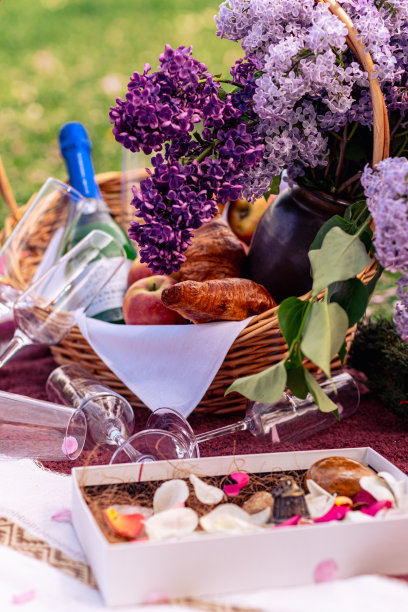 静物画，一篮丁香花，玻璃杯，葡萄酒，水果和羊角面包。美丽的野餐特写照片图片下载