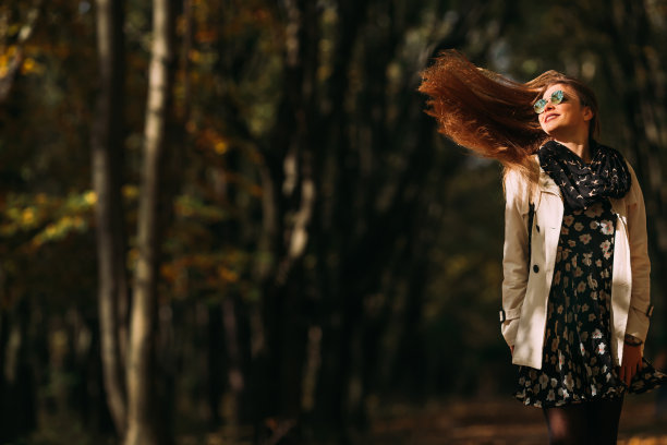 在户外享受大自然的开朗女孩。美丽的秋天头发模型与波浪发光的头发。动态照片。图片下载