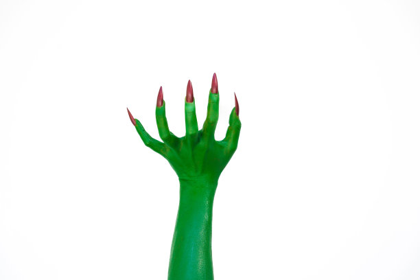 一只长着长指甲的绿色怪物手，孤立在黑暗的背景下，唤起了恐怖和恐惧。非常适合万圣节，这张令人毛骨悚然的图片捕捉到了邪恶和亡灵的本质。图片下载