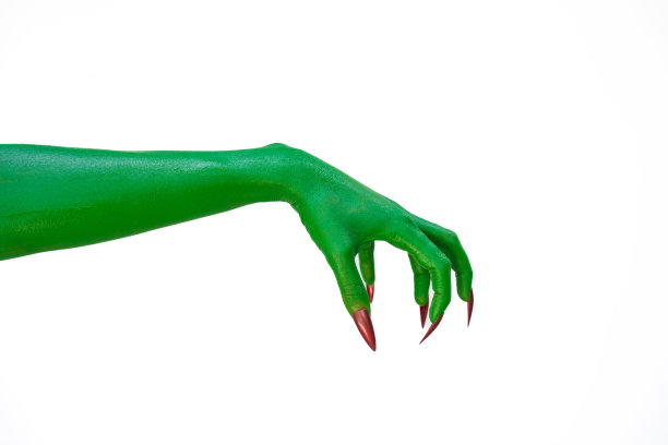 一只长着长指甲的绿色怪物手，孤立在黑暗的背景下，唤起了恐怖和恐惧。非常适合万圣节，这张令人毛骨悚然的图片捕捉到了邪恶和亡灵的本质。图片下载